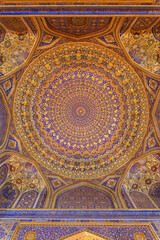 Painted gilded dome of Madrasa Tilya Kori (Registan complex). Arabic text of Koran (sacred book of muslims) used as part of ornament. Gold and blue. Samarkand, Uzbekistan