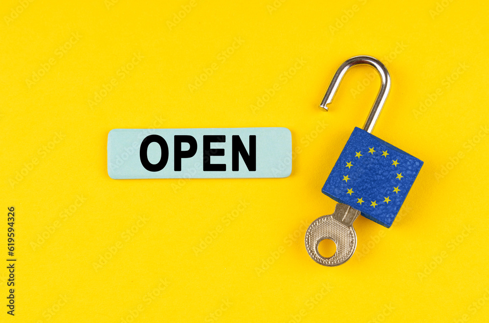 Poster On the yellow surface is an open lock with a key and a sticker with the inscription - open