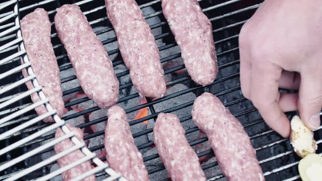 Home chef preparing a BBQ recipe - the Balkan kebapche or cevapcici. Closeup shot. High angle.