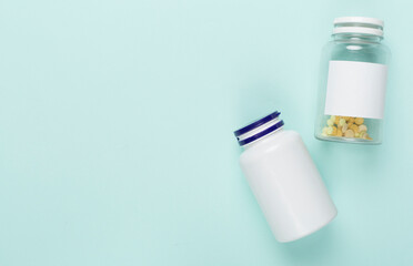Plastic bottles with vitamins on color background, top view