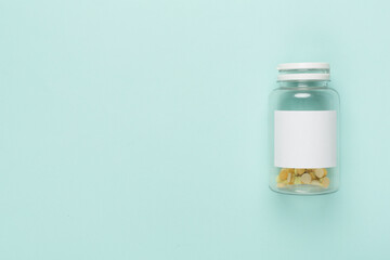 Plastic bottle with vitamins on color background, top view