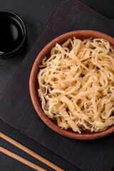 Delicious dried squid in the form of shavings with salt and spices on a ceramic plate
