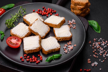 Delicious salty rectangular wheat croutons with cream cheese and tomatoes