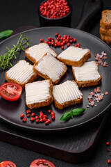 Delicious salty rectangular wheat croutons with cream cheese and tomatoes