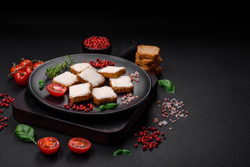 Delicious salty rectangular wheat croutons with cream cheese and tomatoes