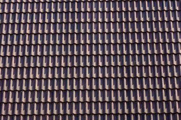 Dark red tiles background details, Old orange roof brick under the sunlight, Shingles texture with green moss, Roof top material, Abstract geometric pattern.