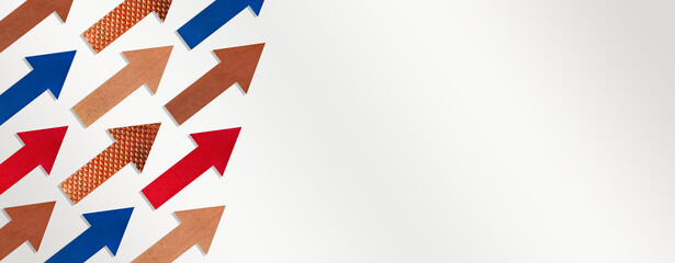 Paper arrows of different colors and textures on gray white gradient background. Copy space. Business concept, growth success. Space for text. Banner or header