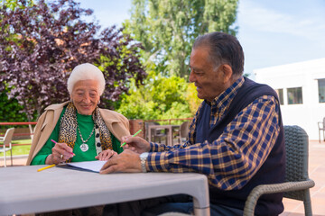 Two elderly people painting in the garden of a nursing home or retirement home, old man and old woman