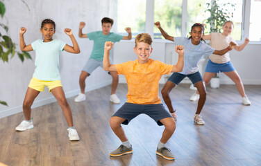 Fototapeta na wymiar Active preteen children practicing Hip-hop dance in training hall during dancing classes