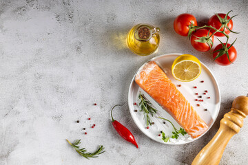 Fresh raw salmon fillet with ingredients for preparation.