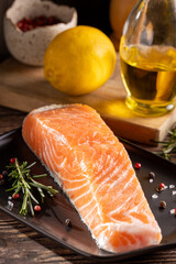 Fresh raw salmon fillet with ingredients for preparation.