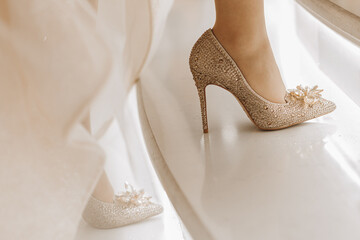 gold-colored high-heeled shoes with swarovski stones. The bride climbs the stairs