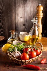 Ingredients for cooking on the table. Tomatoes, peppers, garlic, herbs, oil and spices.