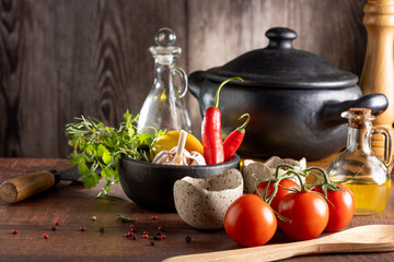 Ingredients for cooking on the table. Tomatoes, peppers, garlic, herbs, oil and spices.