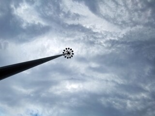 Street lighting pole isolated on blue sky background. Steel or metal illumination pole structure. Large copy space for ad or advertisement text.