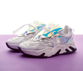 Modern Female white sneakers with holographic details on the purple and white background.