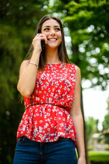 Young beautiful woman on the phone in a park