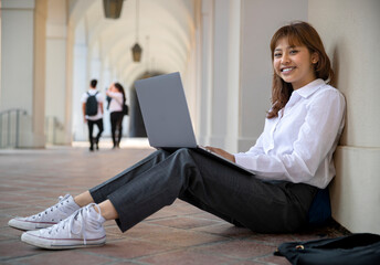 Portrait of a college student, campus life, studying, researching, reading, writing, using computer technology  - 619612508