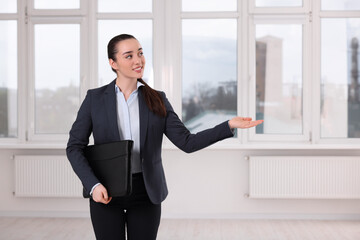 Happy real estate agent with leather portfolio showing new apartment