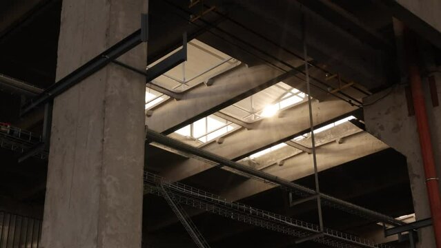 Industrial building, Lighting strategies, Climate considerations. Light from sun floods walls industrial facility, entering through window ceiling.