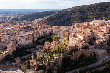 Fototapeta na wymiar Picturesque view from drone of historic district of Cuenca city on steep spur above deep gorges of Jucar and Huecar rivers on sunny spring day, Spain