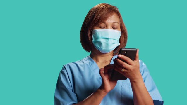 Tense healthcare specialist delivering bad news to patient in telehealth phone chat, close up. Asian nurse overthinking disconcerting message for clinic visitor, isolated over studio background