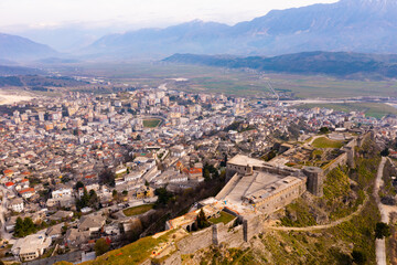 Fototapeta na wymiar View from drone of one of biggest castles in Balkans Gjirokaster citadel on rocky hilltop above city in springtime, Albania..