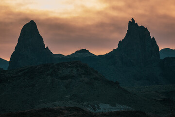 Mule Ears Silhouetted Against Menacing Orange Clouds In Big Bend