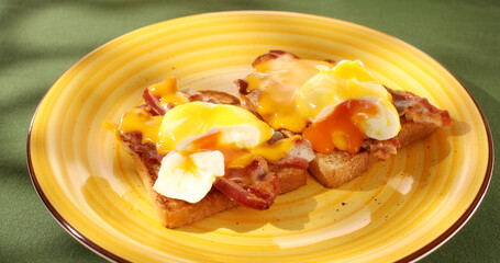 Benedict eggs on a plate. Serving breakfast on a colored background. Boiled eggs on bread with fried bacon and hollandaise sauce. Angle view. Smooth camera movement. Zoom. Sunny day.