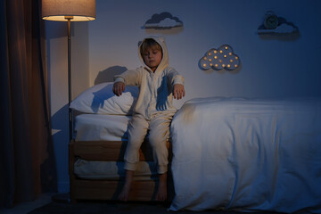 Boy in pajamas sleepwalking indoors at night