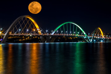 Big Glowing Orange Moon rising over JK Bridge in Brasilia, Brazil