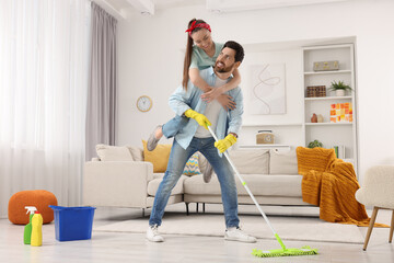 Spring cleaning. Couple having fun while tidying up living room