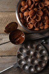 Making walnut shaped cookies. Cooked dough, caramelized condensed milk and mold on wooden table, flat lay