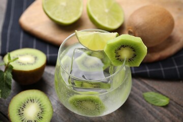Glass of refreshing drink with cut kiwi on table, closeup