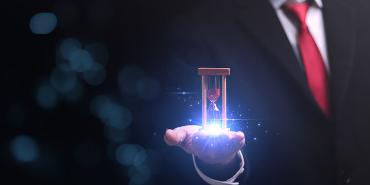 hourglass on businessman hand, time management concept ,effective business planning ,time management organization ,Agreement and solution ,end of deal ,profitable use of time ,appointment punctuality