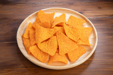 Crispy nachos in wooden plate on wooden background, Corn chips on wooden table.