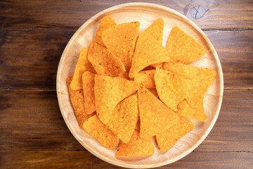 Crispy nachos in wooden plate on wooden background, Corn chips on wooden table.