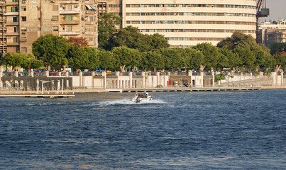 Naklejka premium Egypt, Cairo - View of Nile River and a Boat with Modern Skyscrapers in the background.