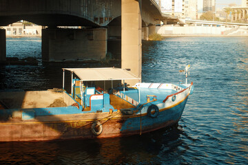 Fototapeta na wymiar Egypt, Cairo - Boat in the Nile River under Bridge, Downtown Cairo.