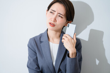 スマートフォンを使う若い女性　ビジネスイメージ	
