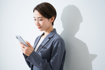 スマートフォンを使う若い女性　ビジネスイメージ	
