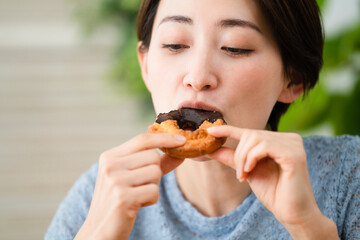 ドーナツを食べる若い女性　飲食イメージ