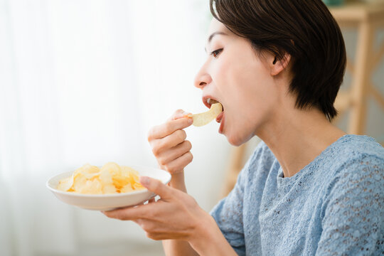 ポテトチップスを食べる若い女性　飲食イメージ