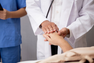 Closeup hands of doctor man encourage with elderly patient at the hospital, physician take care and holding hands for consoling senior sick, diagnostic disease and illness, medical concept.