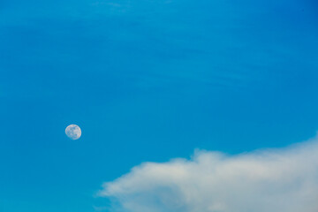 View of light clouds with moon and blue sky, countryside Chiangmai province  Thailand.