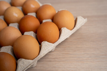 Fresh Chicken eggs in carton box on wooden table. From natural organic farm