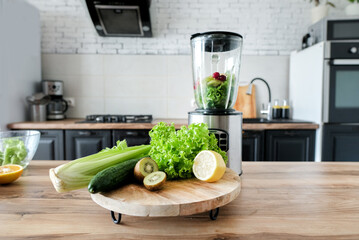 Blender with ingredients for smoothie and products on wooden table in kitchen