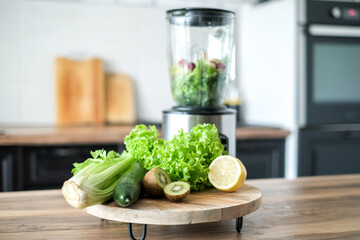 Blender with ingredients for smoothie and products on wooden table in kitchen