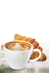 Cup of Cappuccino fresh coffee with croissant