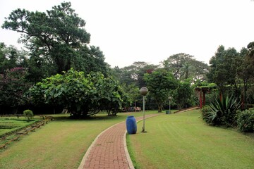 Jakarta – June 10, 2016:  Taman Rekreasi Wiladatika, Tree-lined paths, a swimming pool, a toy train & kids' play areas within a vast green space. 